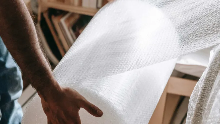 Man wrapping furniture in bubble wrap
